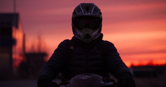 Moto Riding - A Person in Black Puffer Jacket and Helmet Riding a Motorcycle